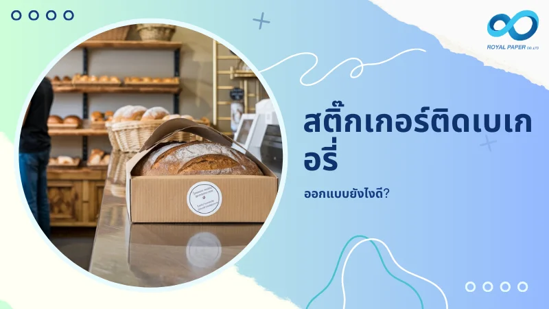 ขนมปังที่ถูกบรรจุในกล่องกระดาษพร้อมสติกเกอร์เบเกอรี่ติดอยู่ด้านหน้า วางอยู่บนเคาน์เตอร์ในร้านเบเกอรี่ พร้อมข้อความ 'สติ๊กเกอร์ติดเบเกอรี่ ออกแบบยังไงดี?'