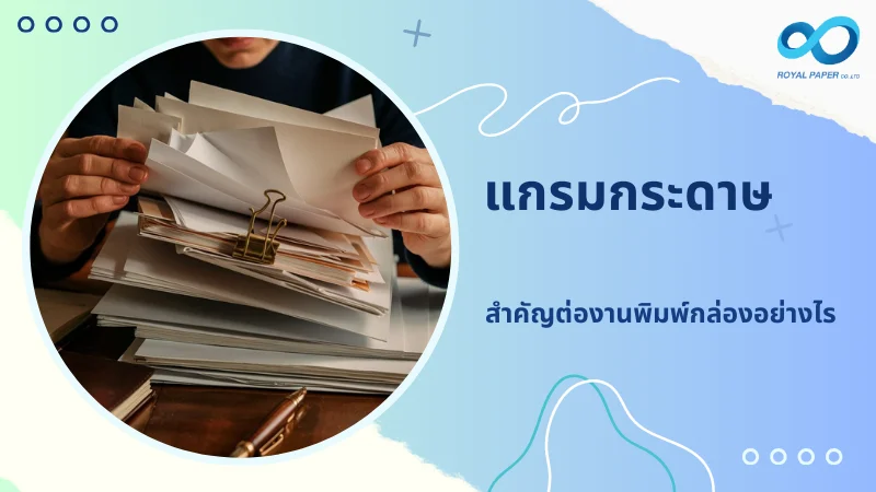 มือคนกำลังจัดเรียงกระดาษหลายแผ่นเพื่อใช้ในการพิมพ์กล่อง