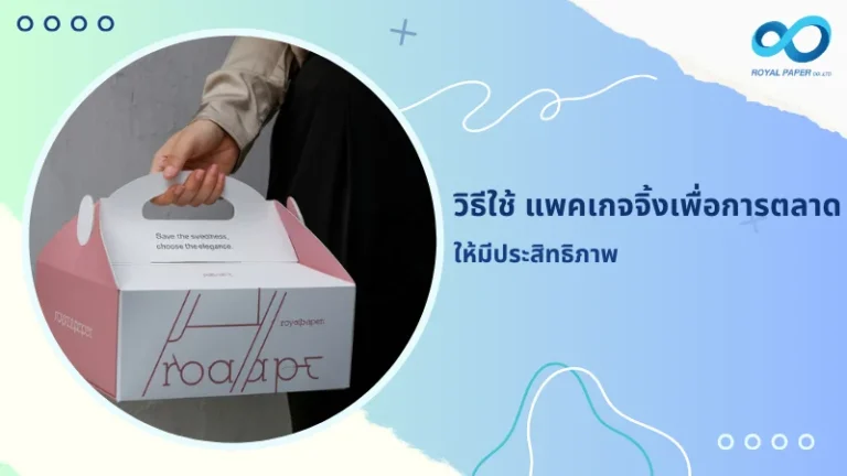 มือถือกล่องบรรจุภัณฑ์สีขาวและชมพูที่มีดีไซน์โลโก้ royalpaper แสดงตัวอย่างแพคเกจจิ้งที่ออกแบบเพื่อสร้างการจดจำแบรนด์และส่งเสริมการตลาด