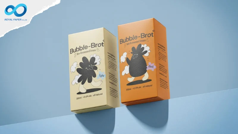 กล่อง Bubble-Brot สีครีมและสีส้มวางเอียงคู่กันบนพื้นหลังสีฟ้า